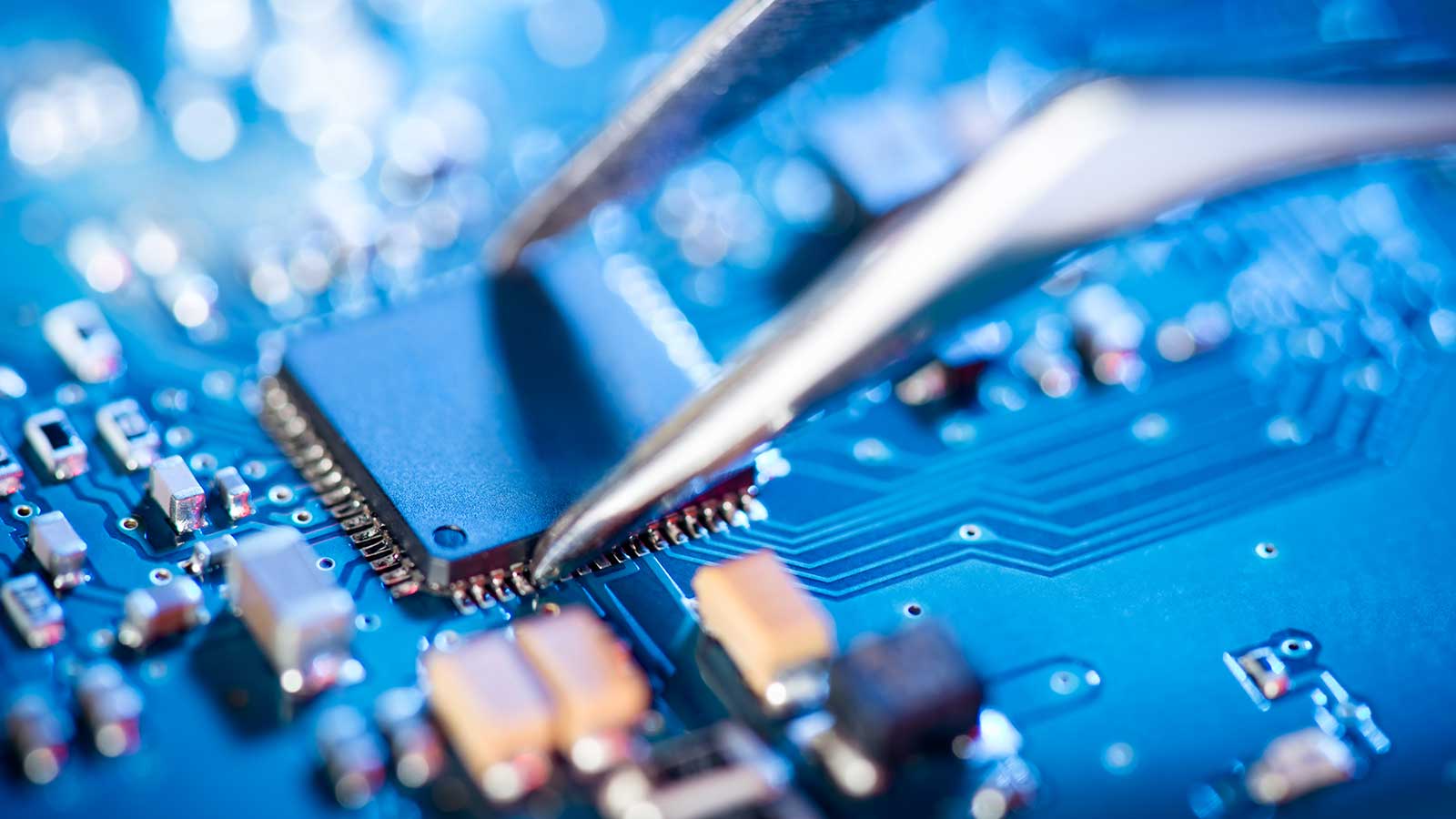 computer chip being placed on a circuit board representing electrical computer engineering program at Clarkson university