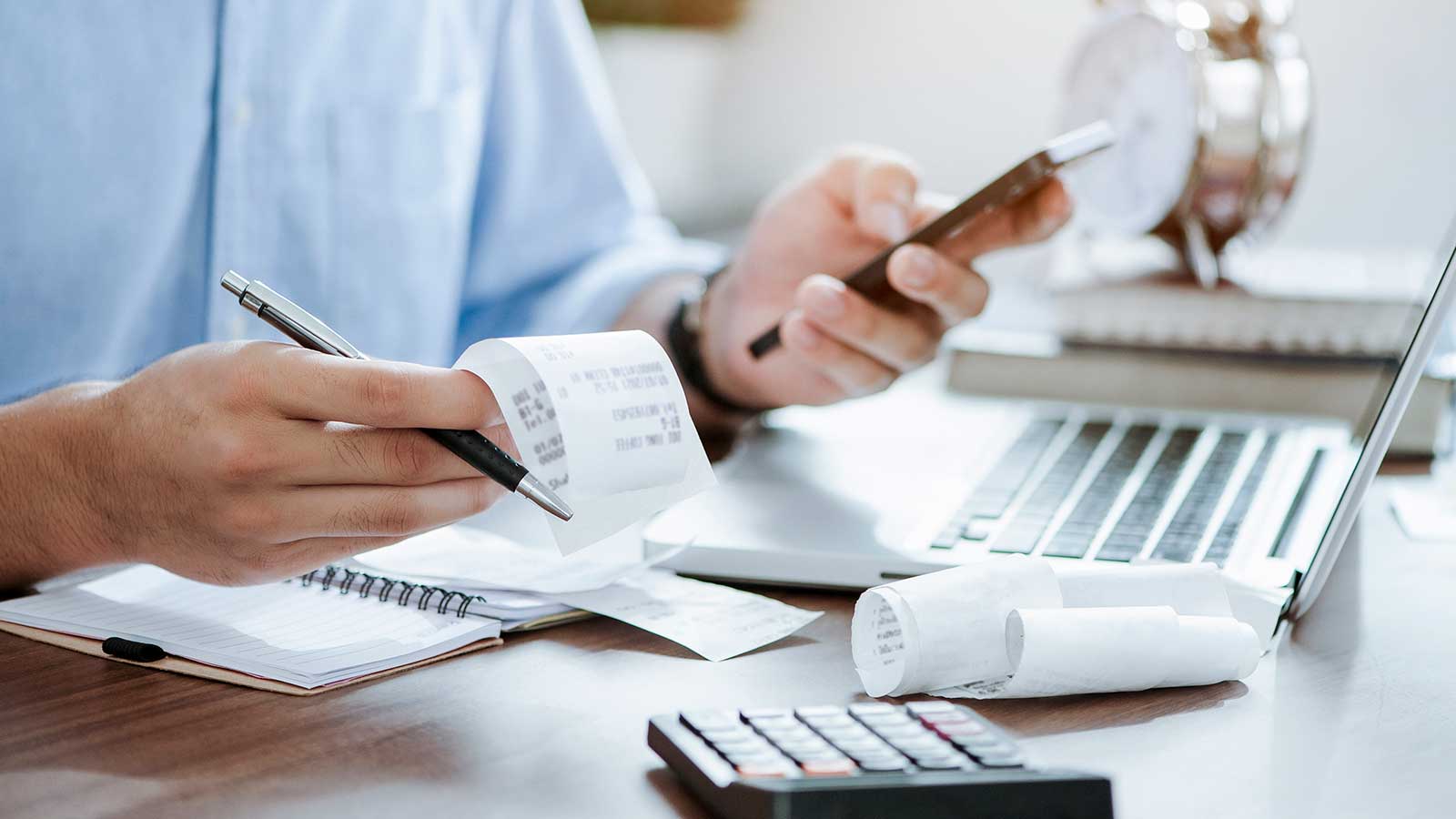 person with receipts and calculator representing financial information analytics program at Clarkson university