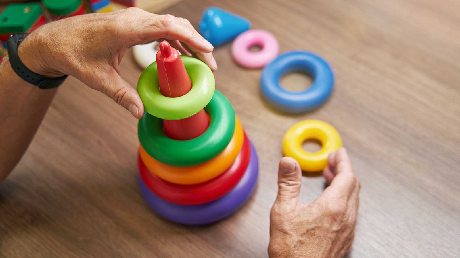 Person organizing colored plastic rings representing occupational therapy program at Clarkson university