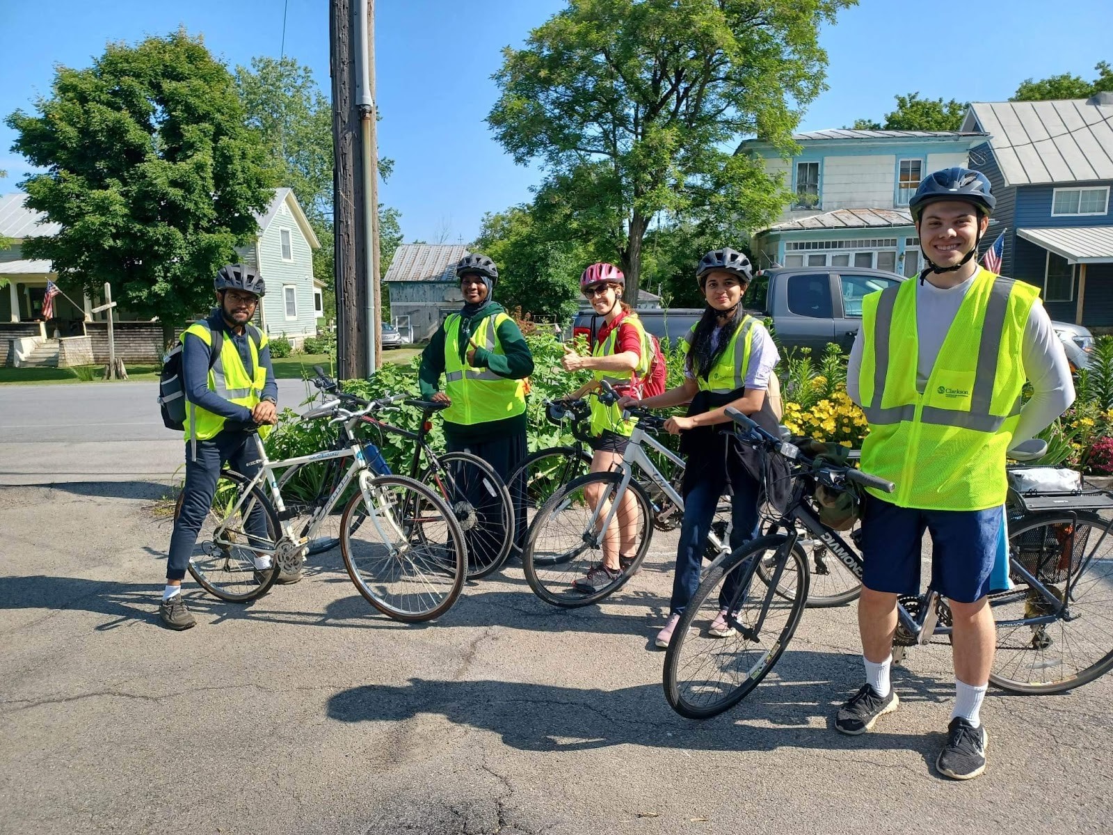 Students pose on bikes wearing high visibility vests