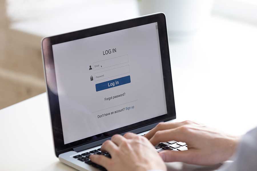 Individual signing into a website on a laptop