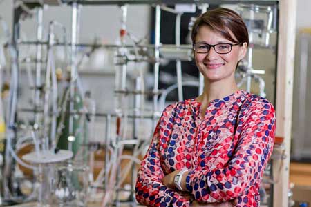 Prof. Prof. Selma Mededovic standing with her arms folded, in front of laboratory equipment.