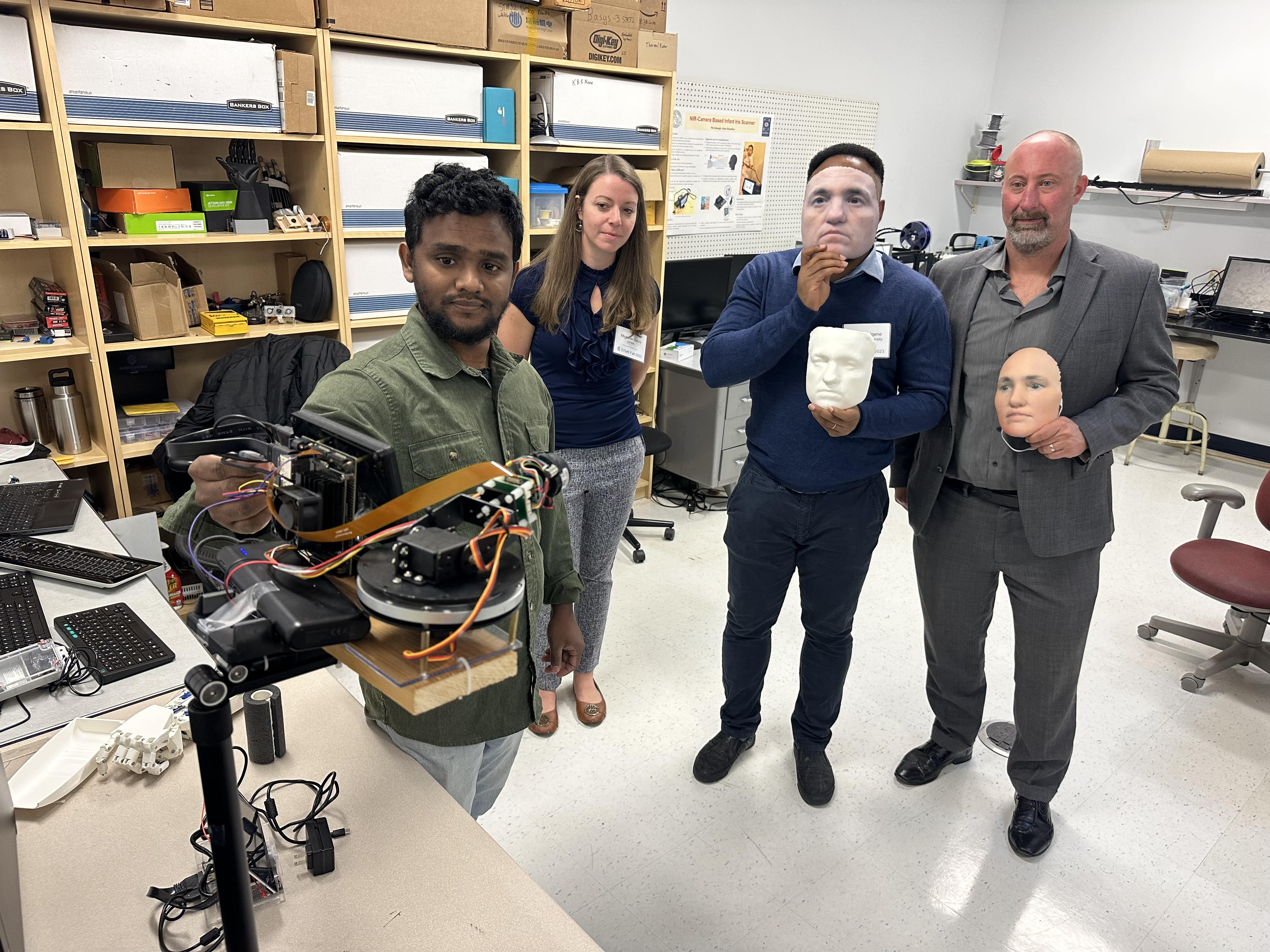 A student operates a facial recognition camera as representatives from DFBA hold mannequins for the machine to scan.