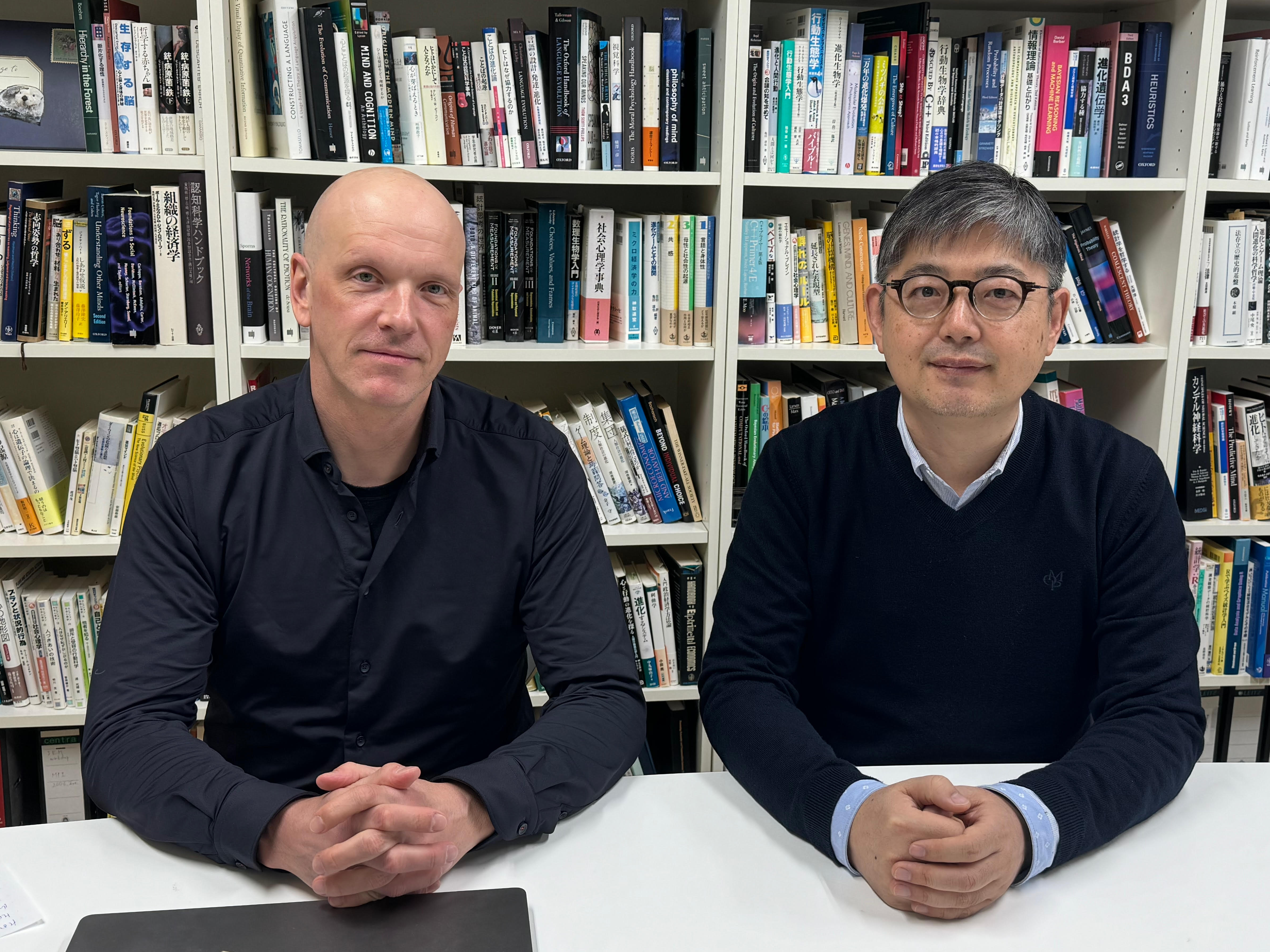 Andreas Wilke and Masanori Takezawa seated side-by-side in an office.