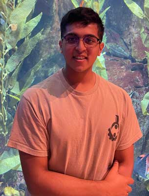 Waist-up portrait of Shreejit Poudyal with warms folded, wearing a tee-shirt