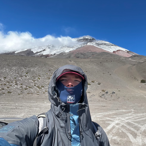 A photo of Sam Ellingson in front of a mountain.