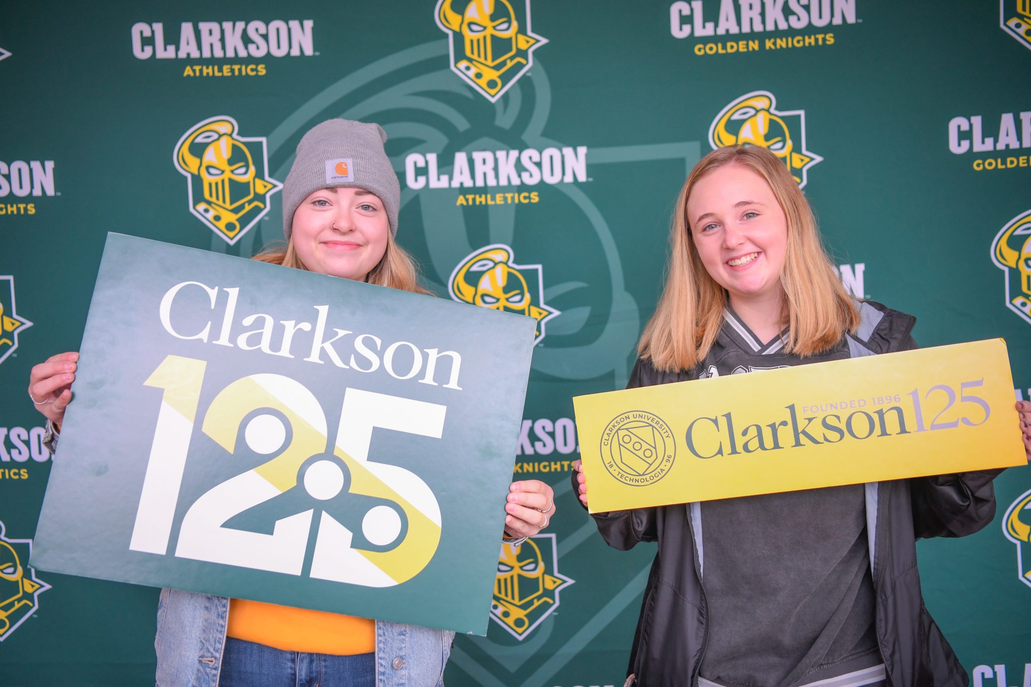 Two students holding up Clarkson 125 anniversary signs. 