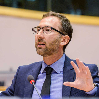 Chest-up portrait of Christian Felzensztein speaking, wearing a blue suit jacket, light blue shirt and dark blue tie.