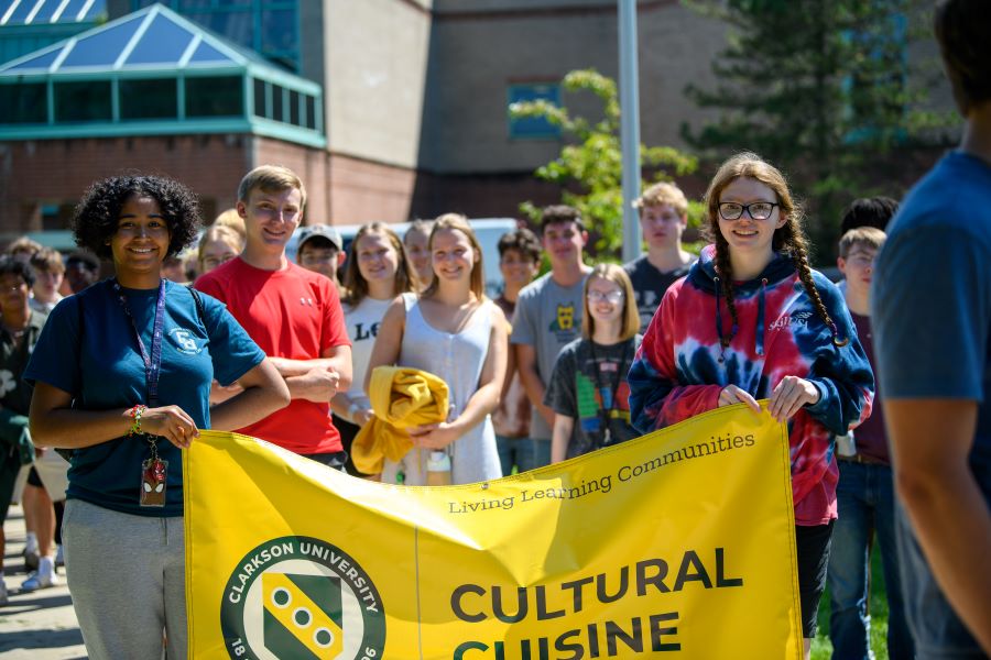 A photo of the fall 2024 cultural cuisine living learning community holding a banner