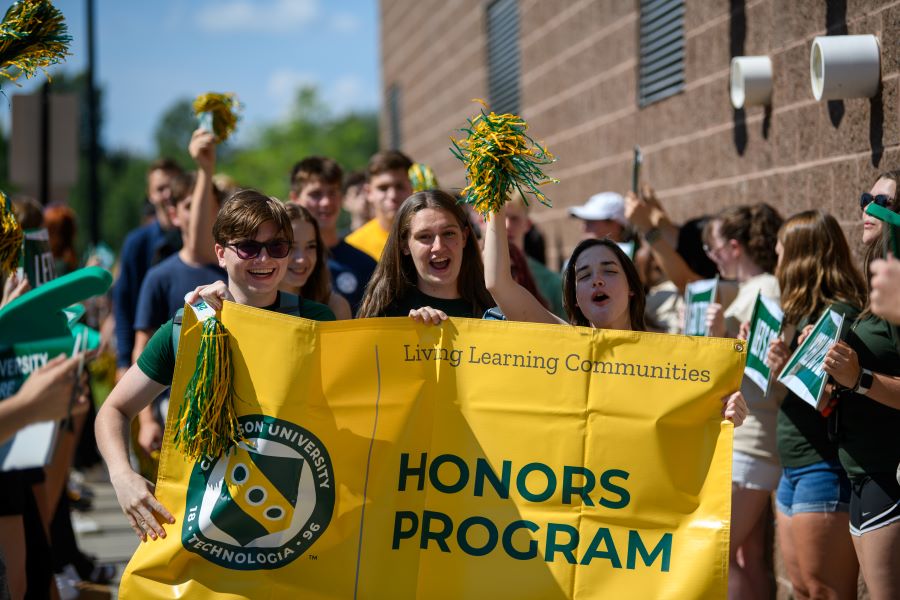 A photo of the fall 2024 honors program living learning community holding a banner.