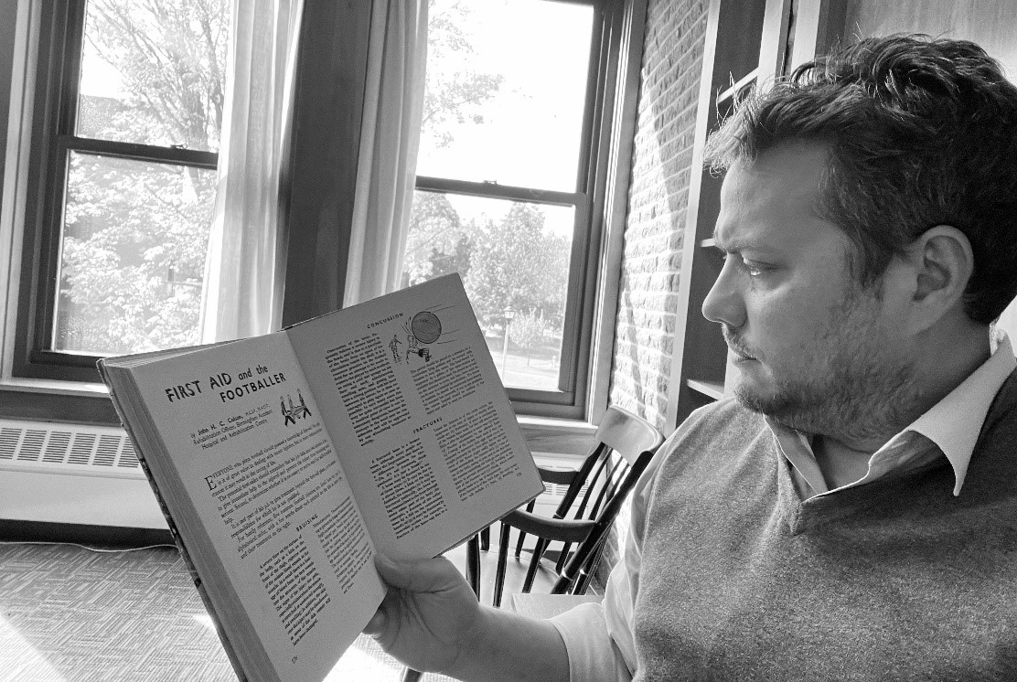 Black and white candid of Stephen Casper reading an open book